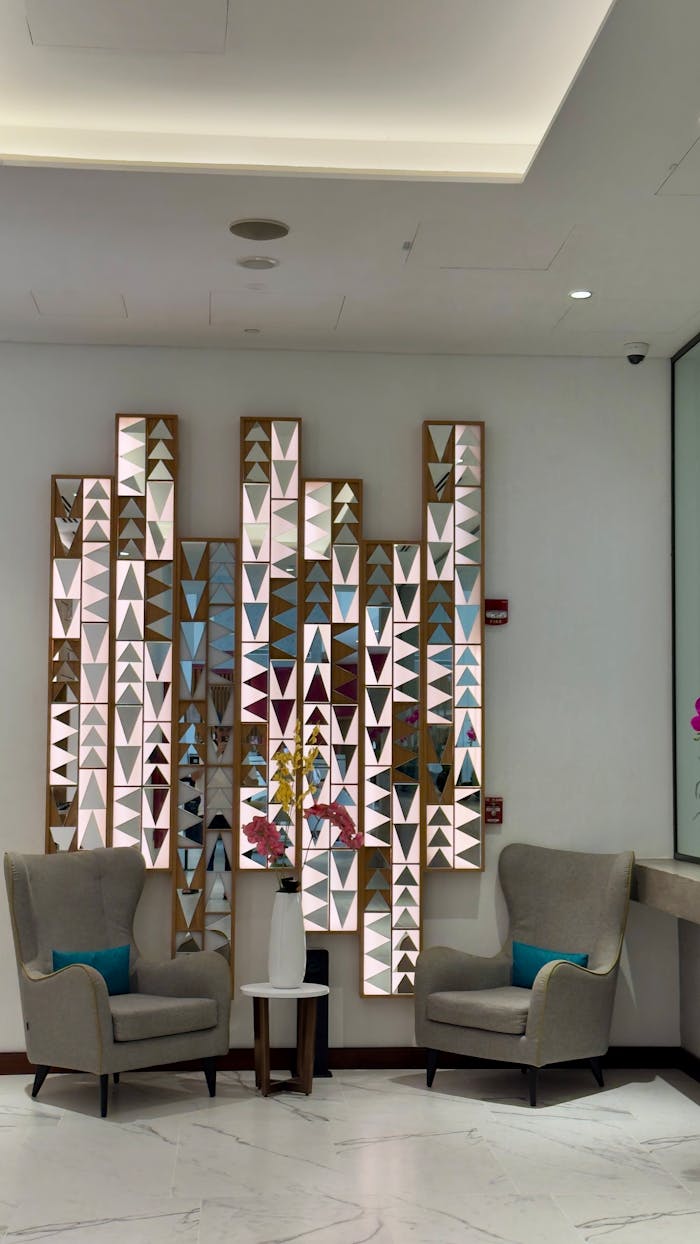 Sleek hotel lobby in Dubai featuring artistic wall panels and plush seating.